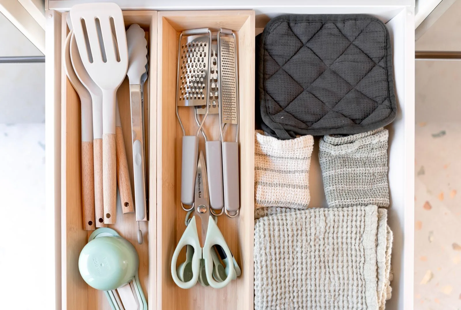 Kitchen drawer with cooking utensils arranged in separate sections