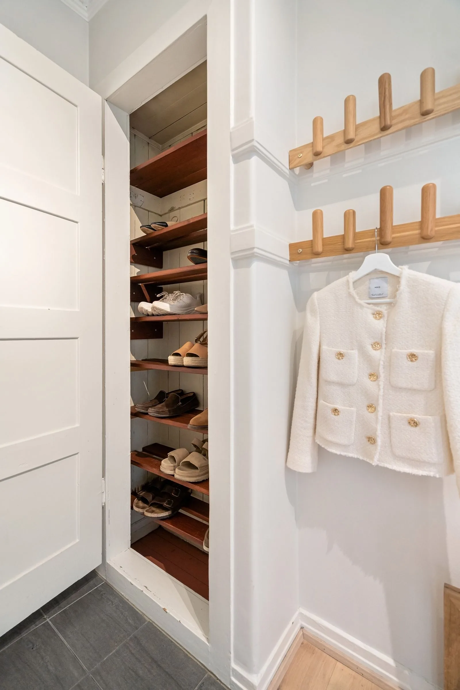 Open wardrobe with shoes arranged on compact shelves