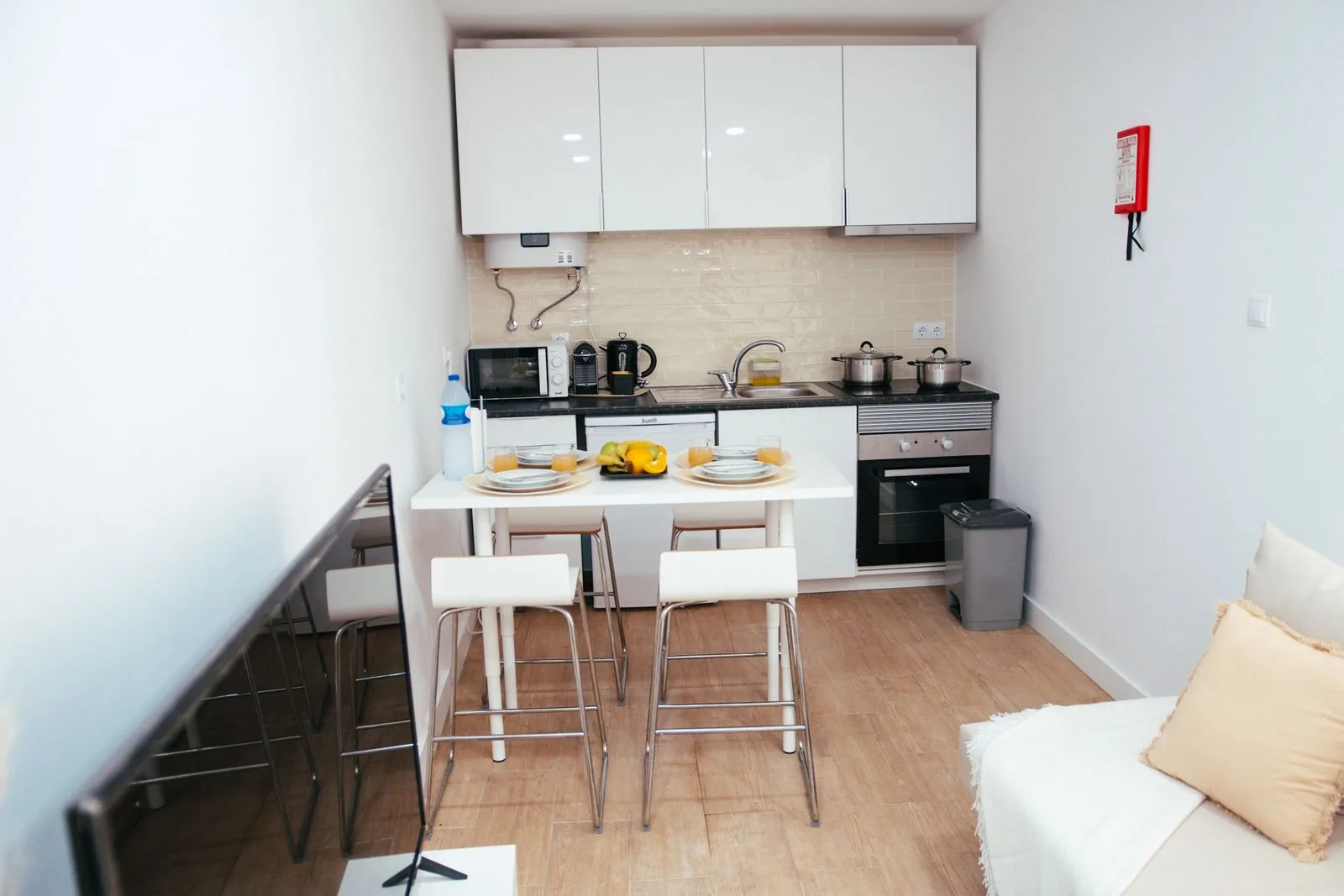 Compact apartment kitchen with white cabinets and open shelving